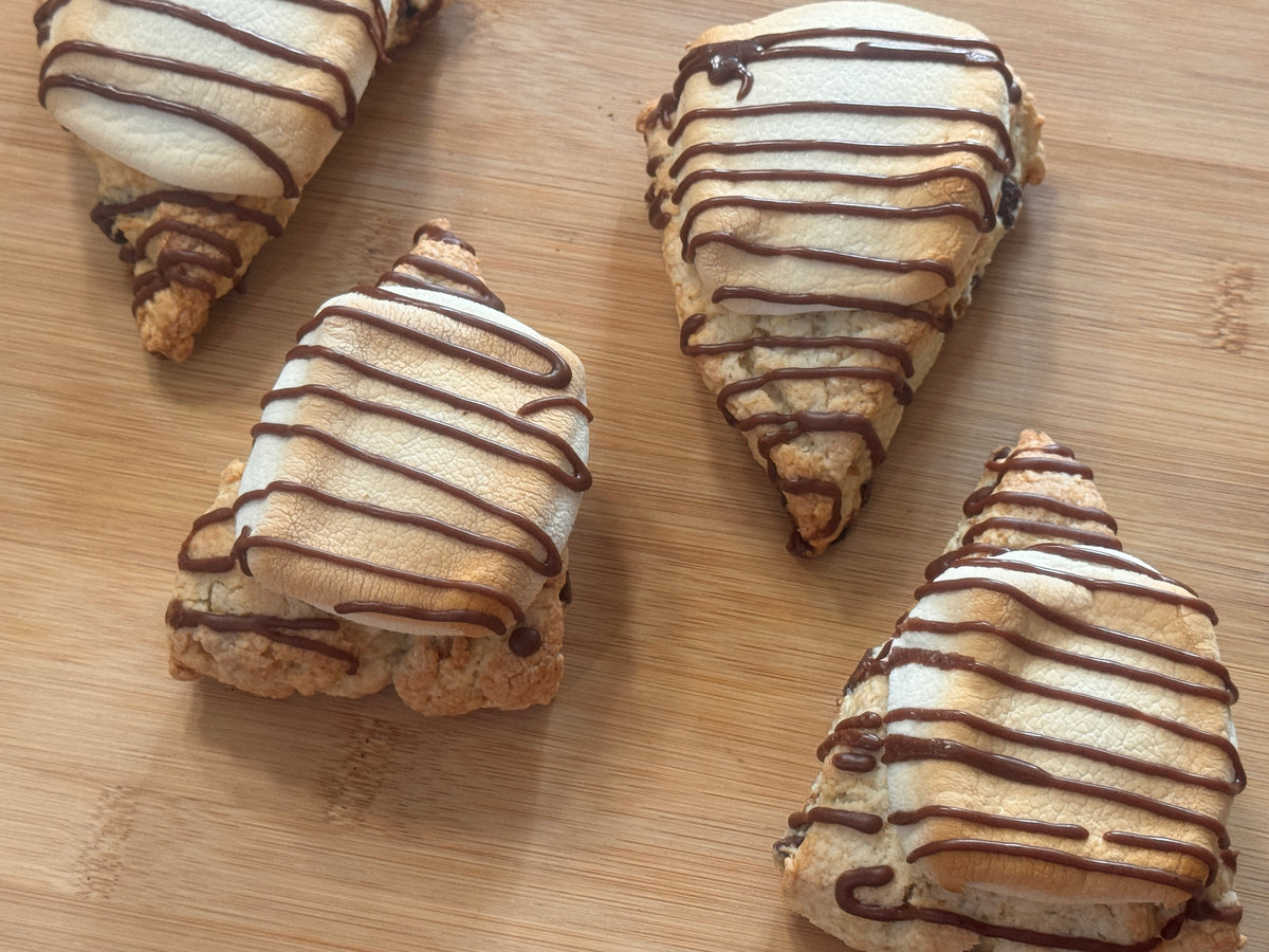 four s'mores scones arranged on a wooden surface