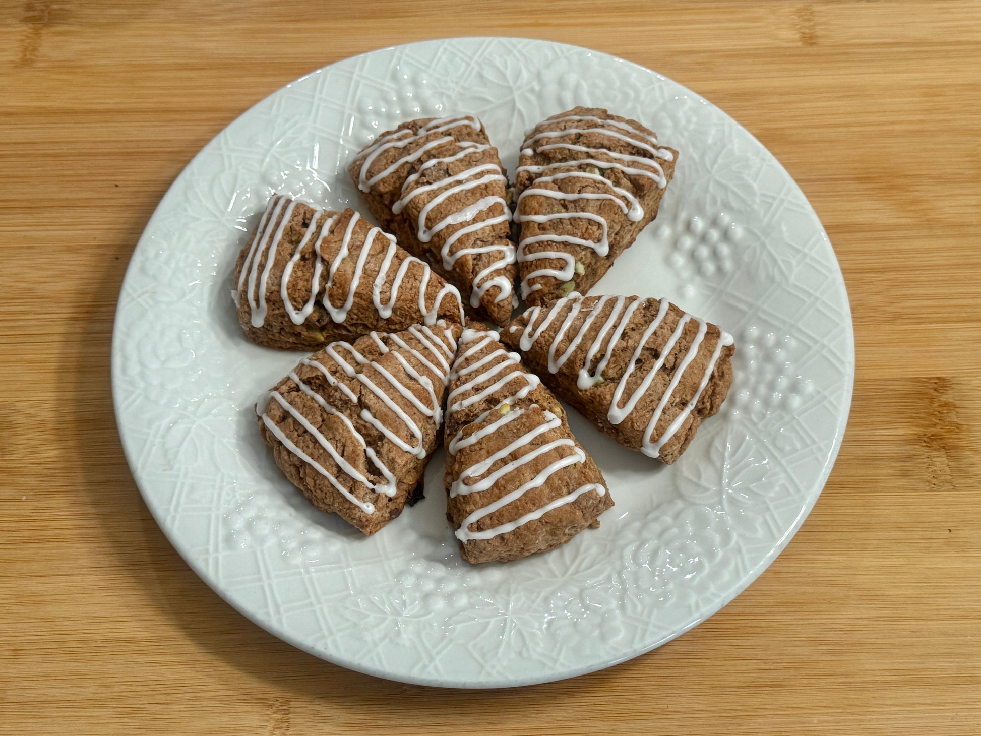 Plate of chocolate mint scones with icing on a wooden surface