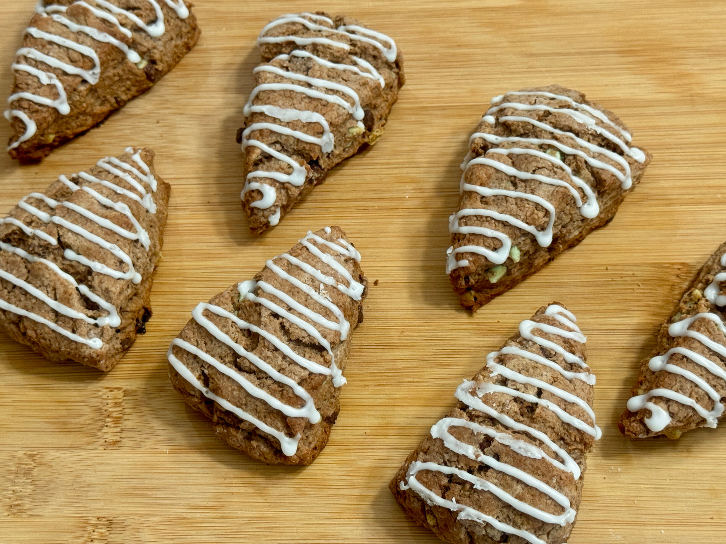 Chocolate Peppermint scones with white icing on a wooden surface