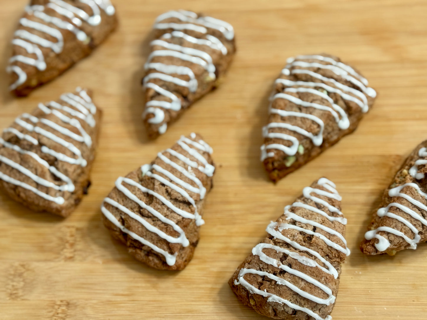 Peppermint Mocha scones with white icing on a wooden surface