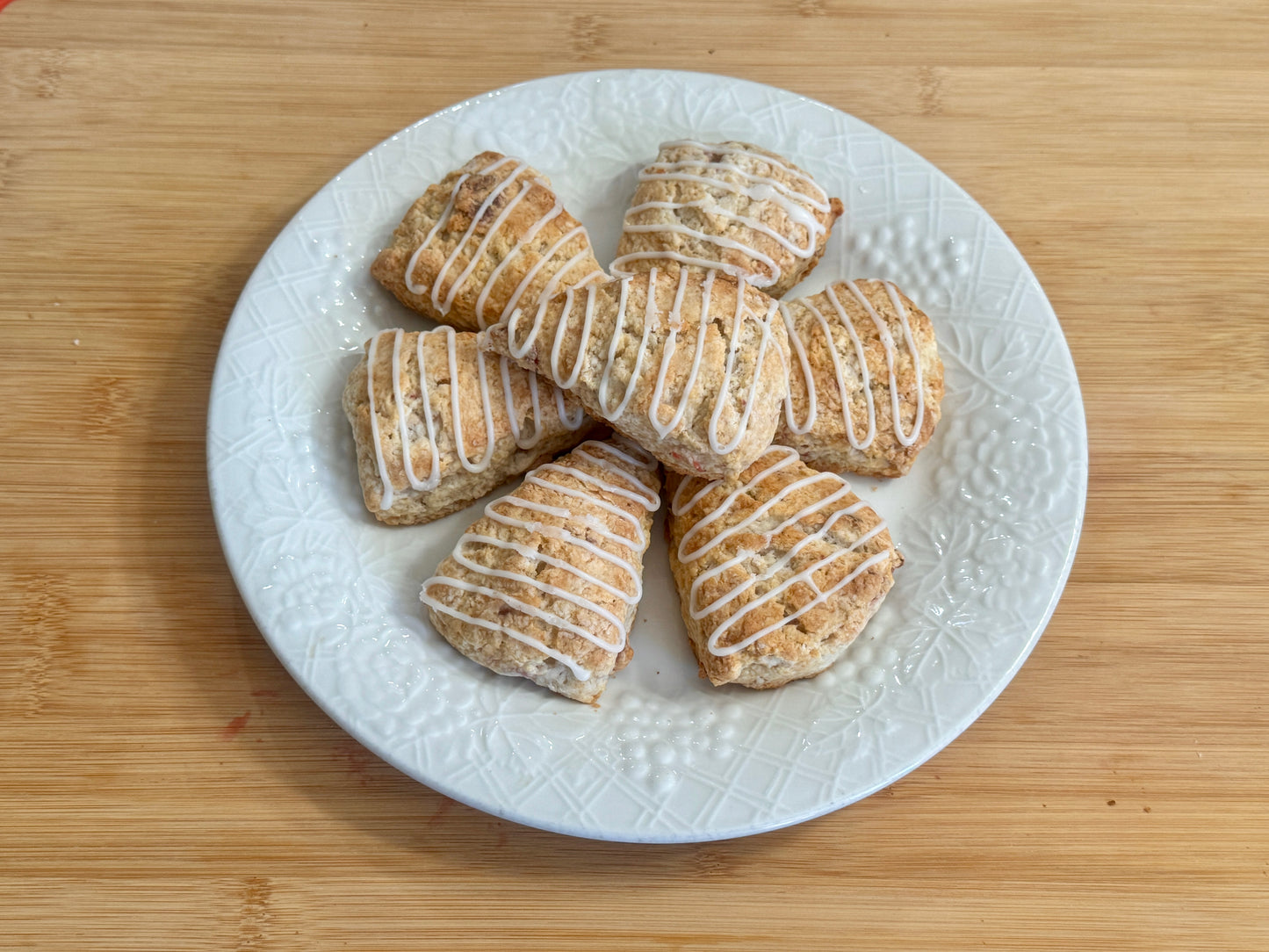 White plate with strawberry minis scones on a wooden surface