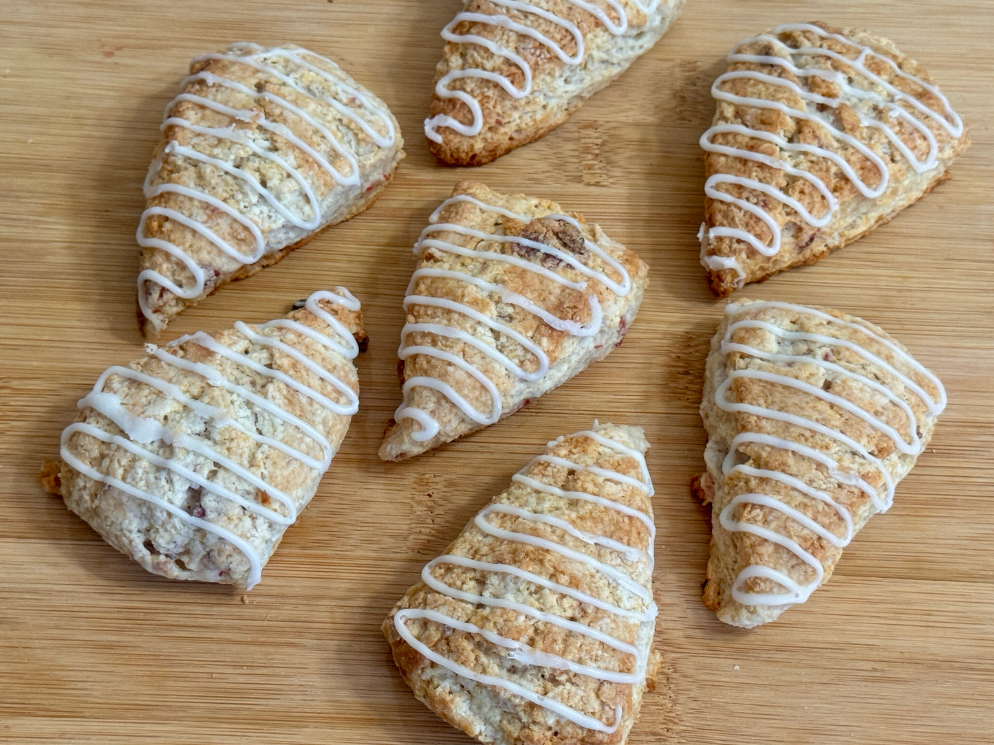 Strawberry Mini Scones with white icing on a wooden surface