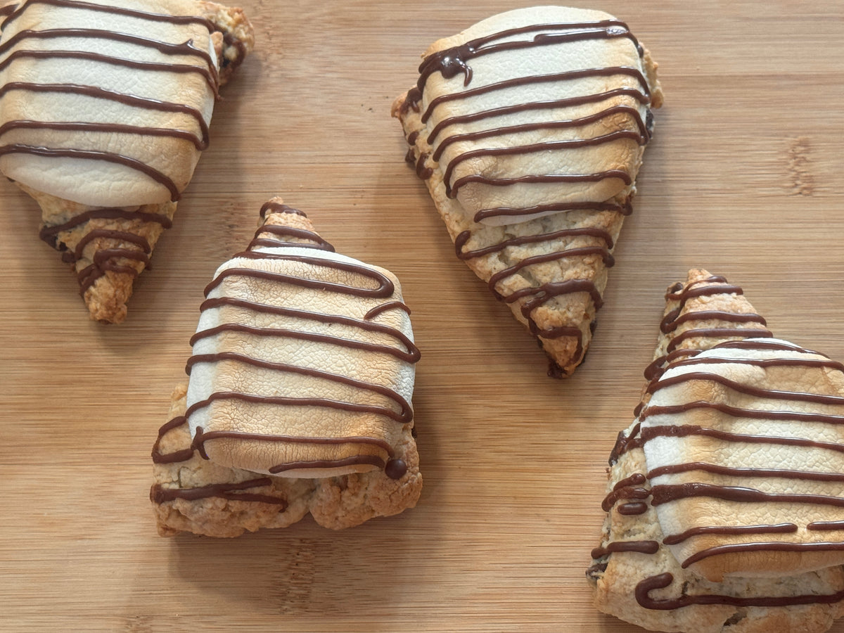 four s'mores scones arranged on a wooden surface